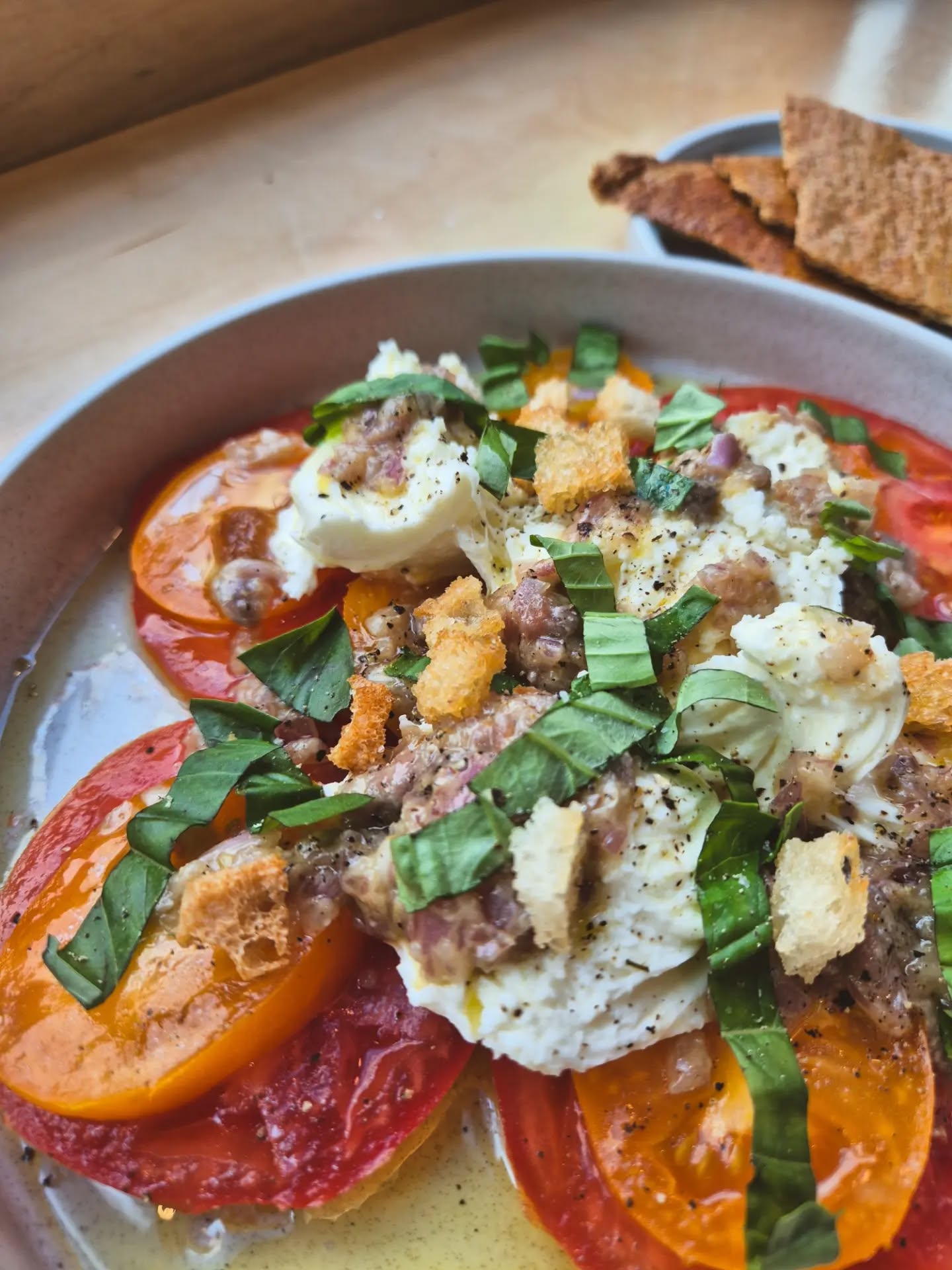 Summer on a plate 🍅 Salted caprese salad, heirloom tomato, buffalo mozzarella, basil, anchovy, croutons,…